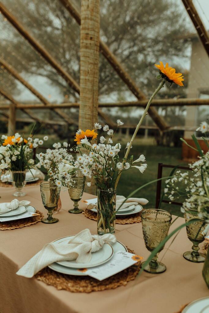 mesa posta com centro de mesa com flores brancas e girassois