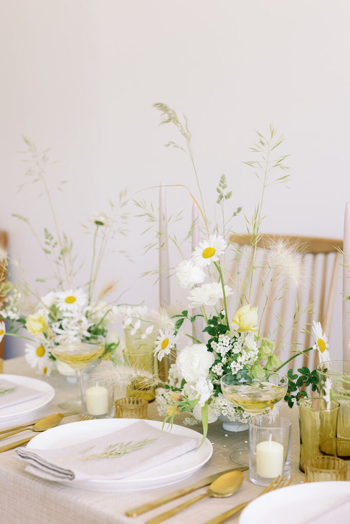 mesa posta decorada com margaridas e plantas