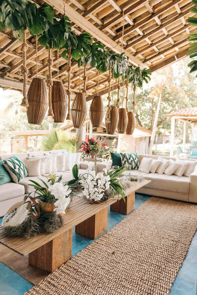 lounge com sofá branco mesa de centro com flores brancas e luminárias rústicas
