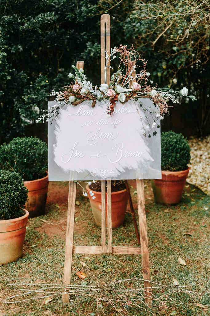 cavalete de madeira com placa de bem-vindos decorado com flores cor de rosa