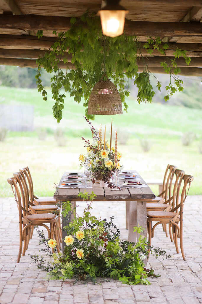mesa rústica com flores amarelas no centro