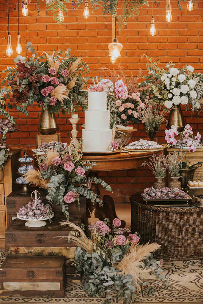 mesa com bolo de casamento com flores rosas