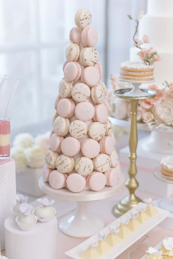 Mesa com doces finos para casamento pirâmide de macarons rosa bebê e branco com desenhos dourados