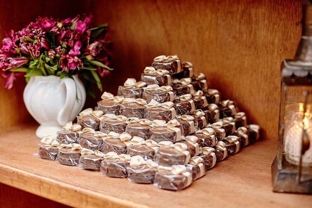 Mesa com doces finos para casamento com pilha com pão de mel com laço dourado