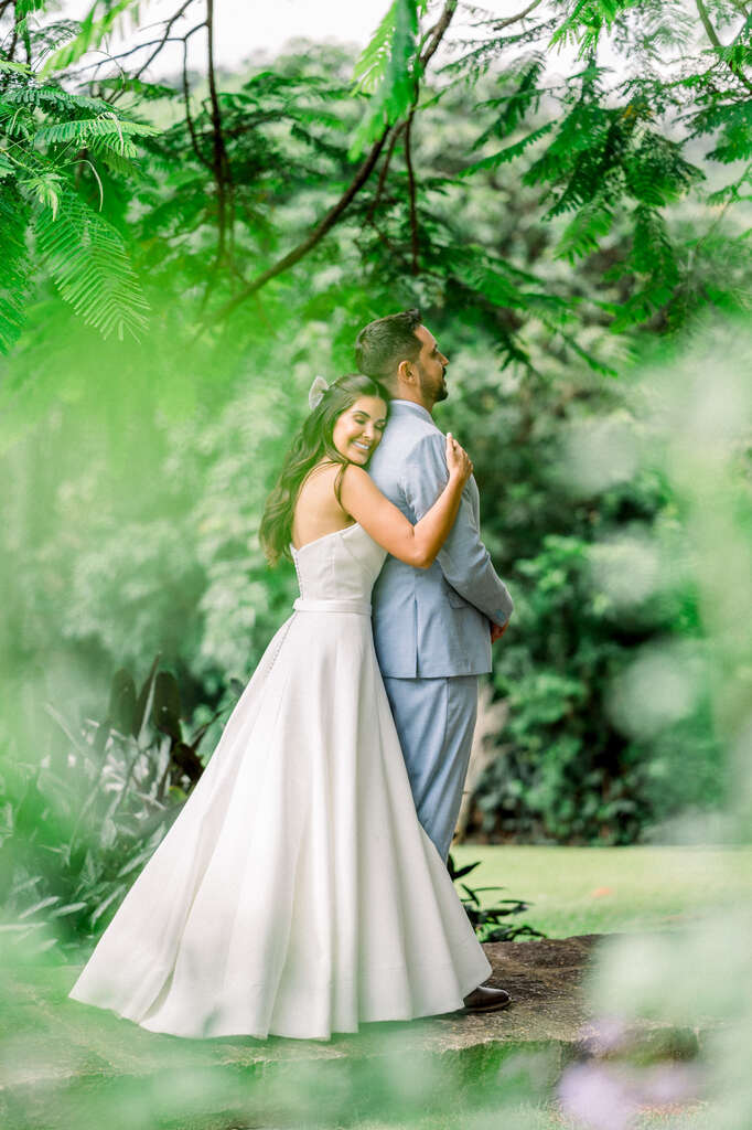 noiva abraçando o noivo com terno azul claro