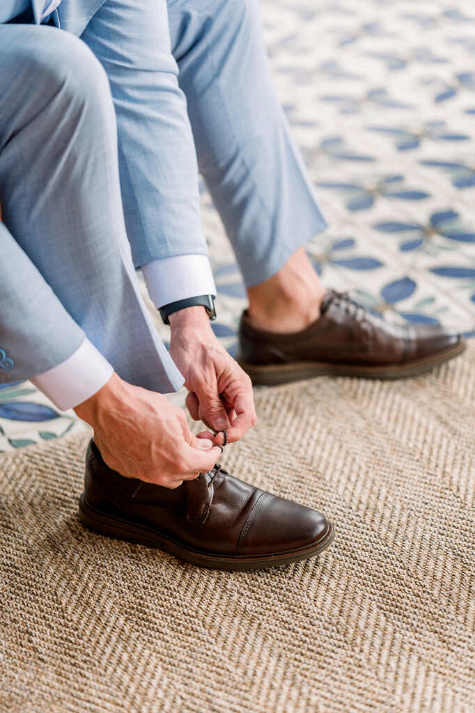 noivo com terno azul claro calçando sapato social de couro marrom