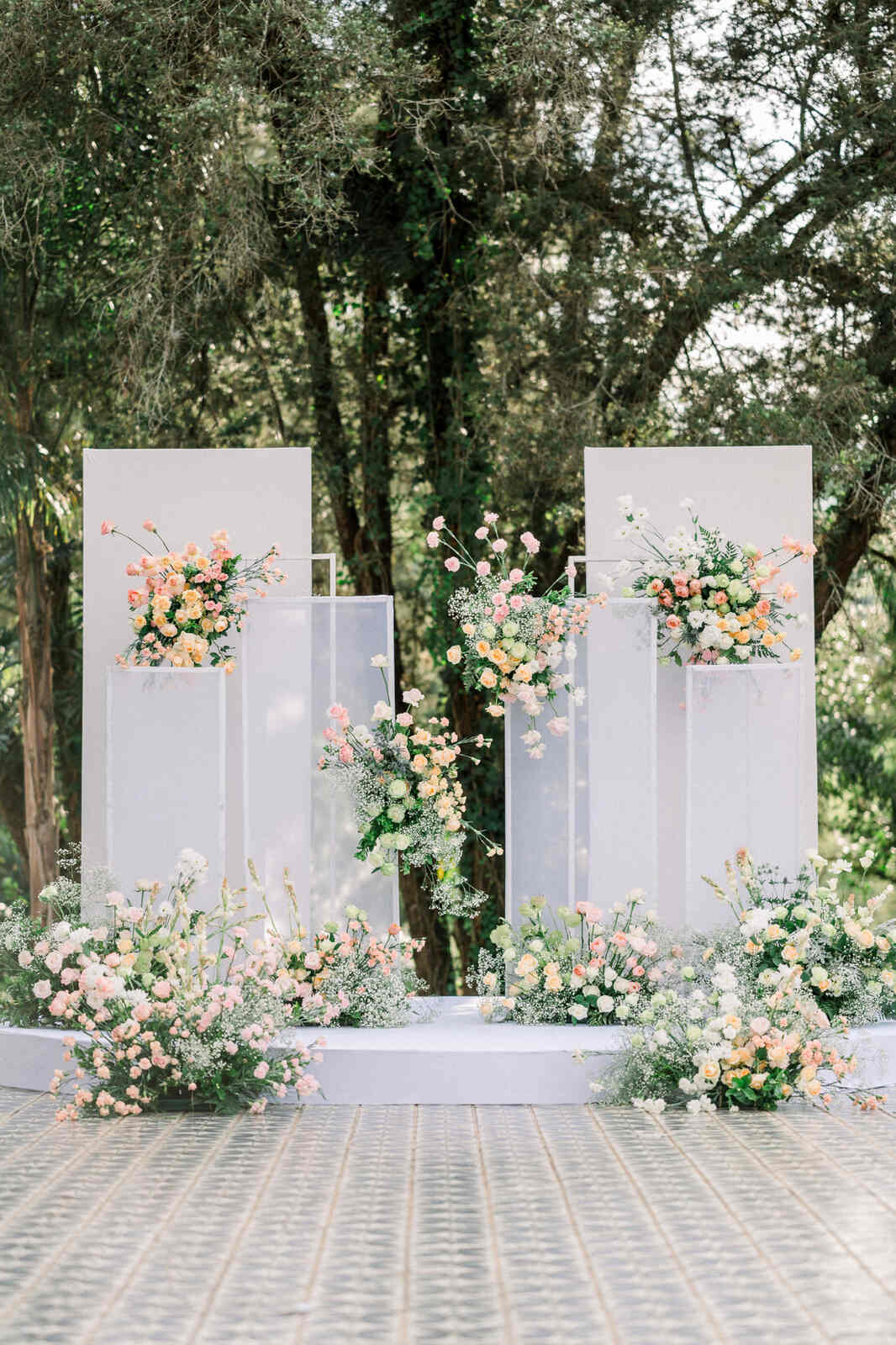 altar com paineis modernos cinzas e transparentes e flores rosas brancas e laranjas