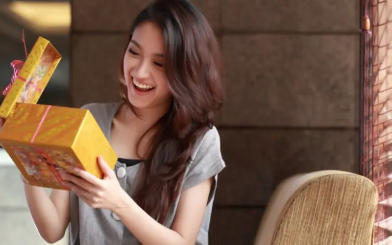 mulher abrindo presente de casamento