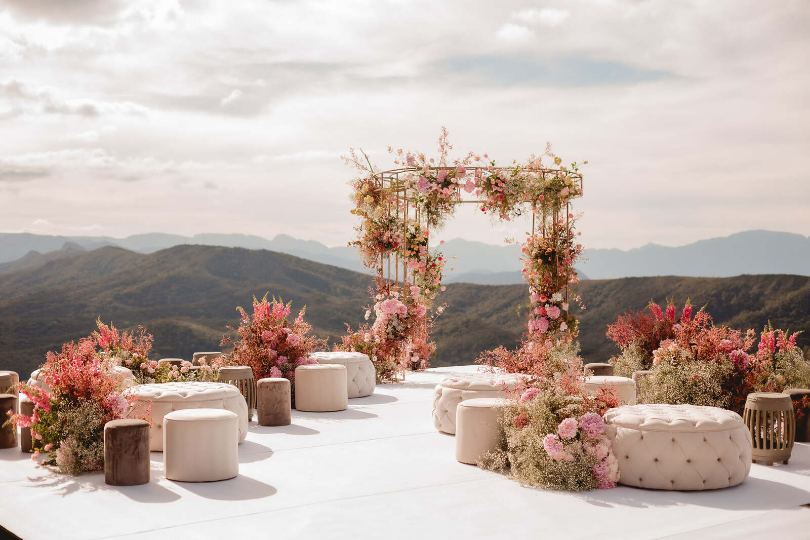 altar para casamenot romântico com flores cor de rosa e puffs com vista para as montanhas