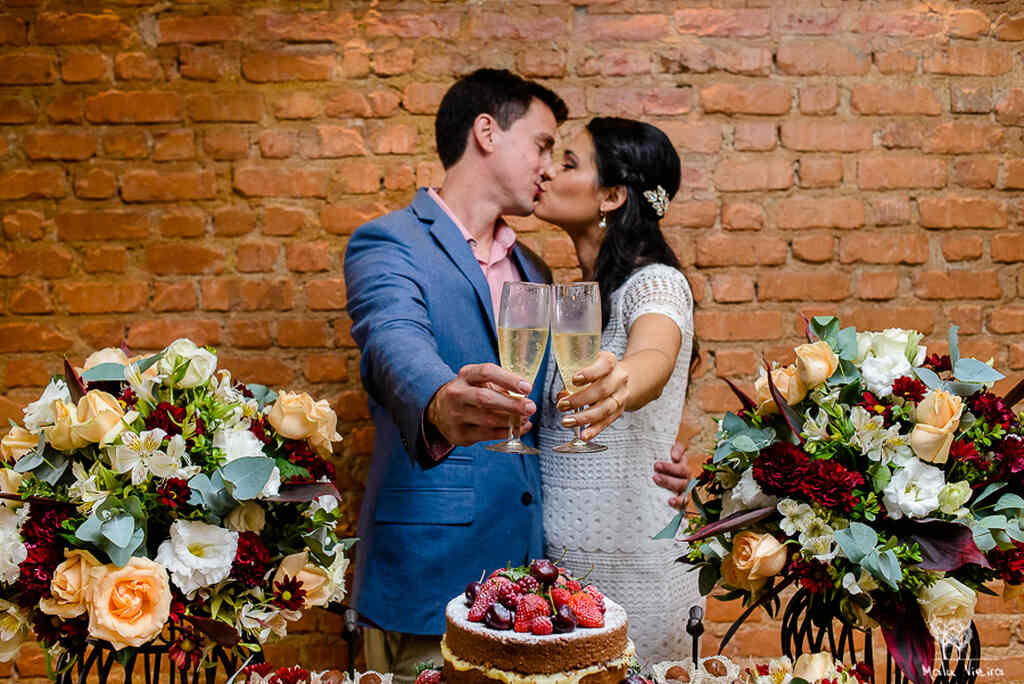 casal de noivos em almoço de casamento civil brindando com champagne
