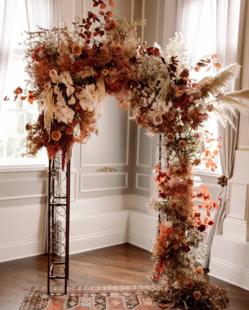 altar de casamento em tons terrosos com arranjos de folhagem