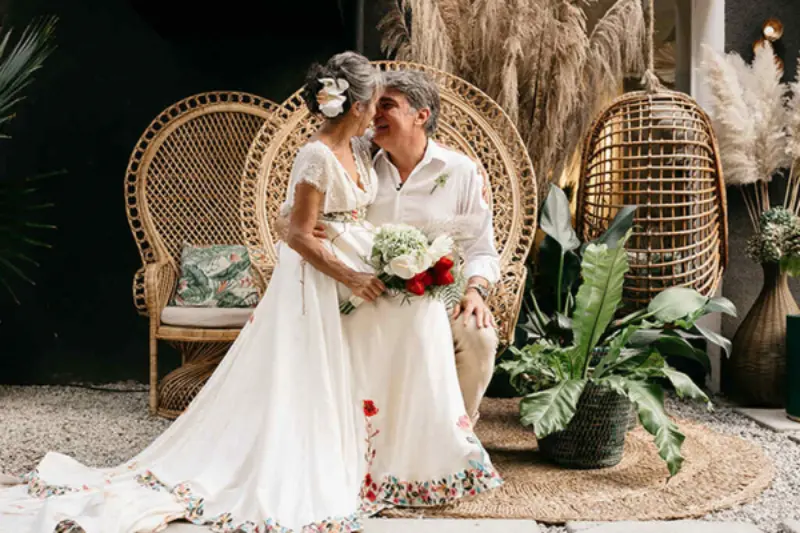 casal sentados em cadeira pavão na celebração de 50 anos de casados