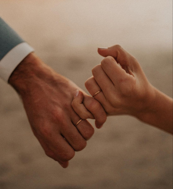 capa post: Duas mãos, a de uma mulher e um homem se entrelaçam pelo dedo mínimo. Em ambas as mãos, no dedo anelar, está uma aliança de ouro.