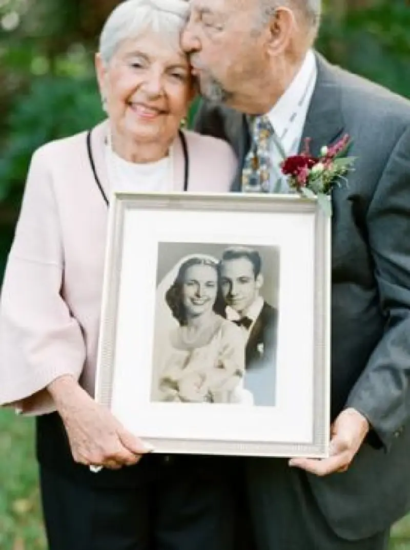 casal de idosos segurando foto do casamento