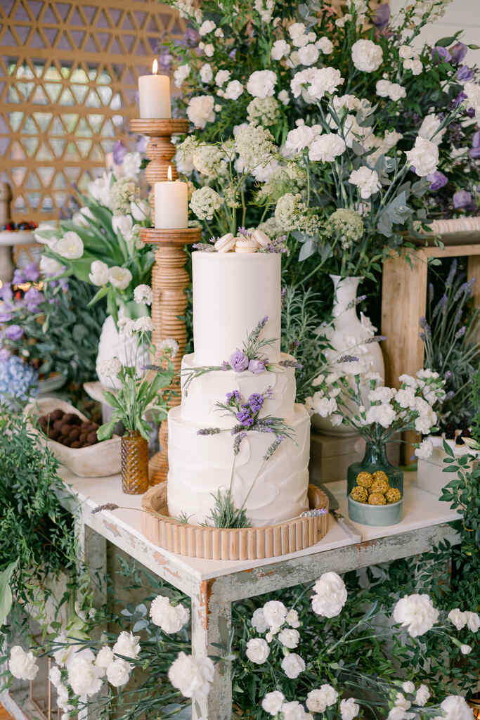 mesa com bolo de casamento branco com tres andares com lavandas