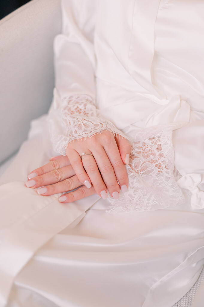 mulher com robe mostrando as unhas de noiva