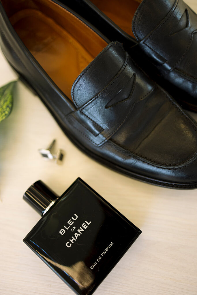 sapato de couro preto ao lado do perfume eau de chanel