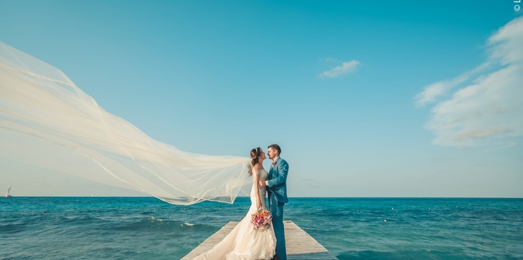 casal de noivos em deck de madeira sob o mar de Cancún