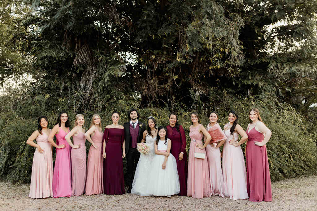 noivos ao lado das madrinhas com vestidos cor de rosa e mães com vestido marsala
