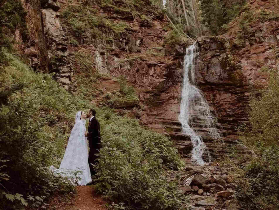 Noivos em meio a natureza, ao lado de cachoeira
