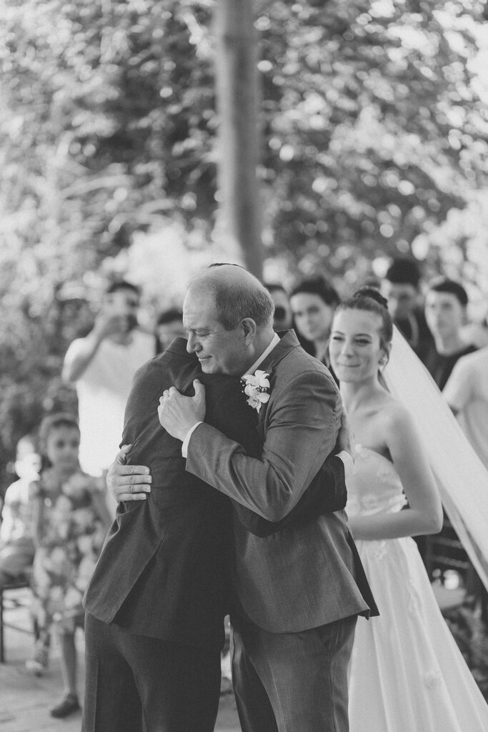 pai da noiva abraçando o noivo