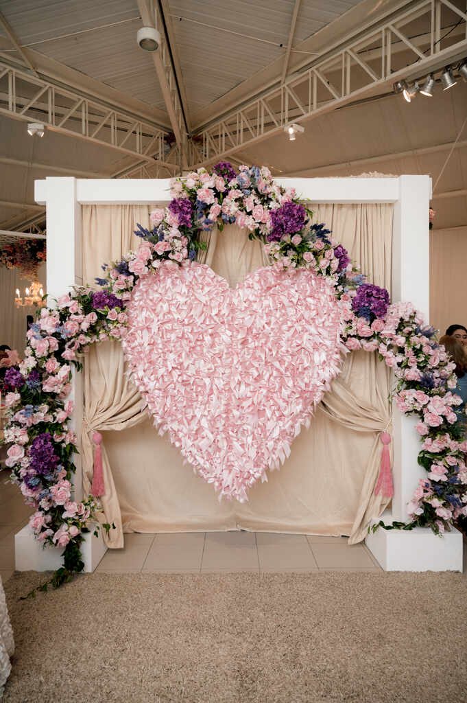 painel para fotos com grande coração cor de rosa e flores