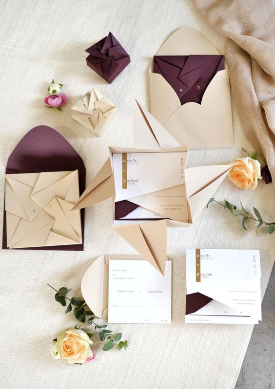 Modelo de convite de casamento feito de origame na cor creme e envelope roxo