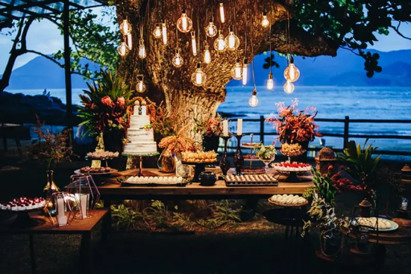 ilumina&ccedil;&atilde;o casamento na praia para mesa de bolo