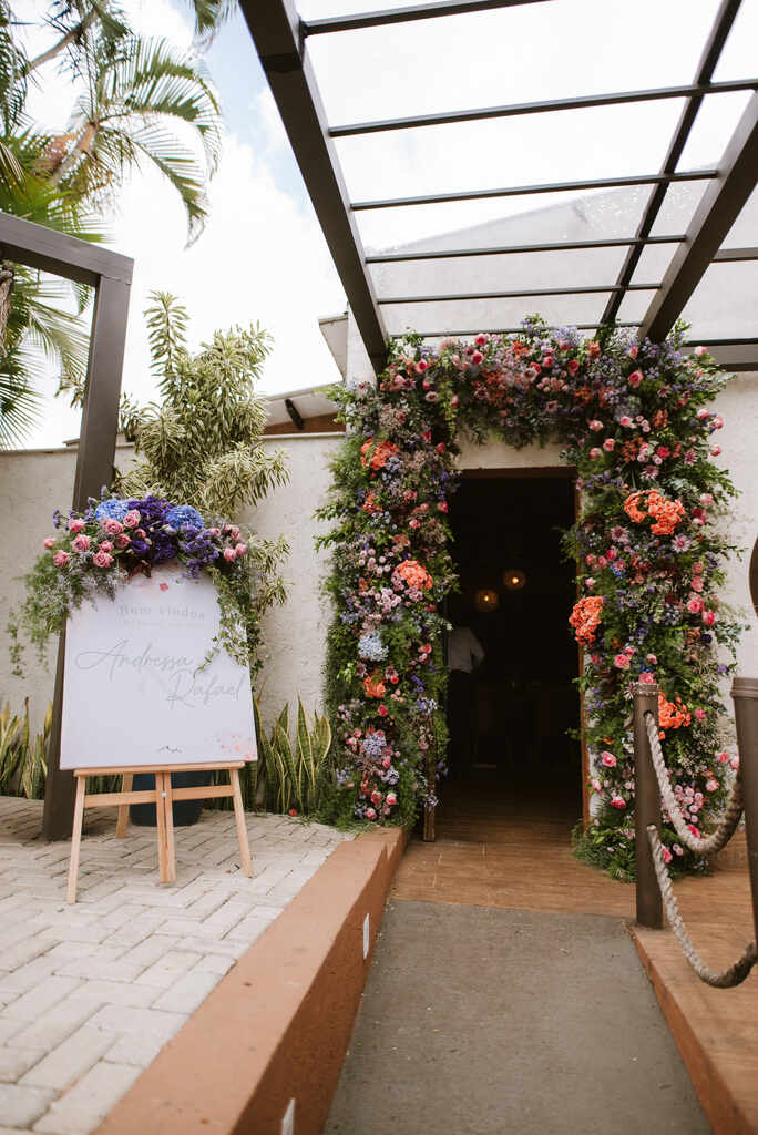 arco de flores romantico na entrada e ao lado placa de bem-vindos