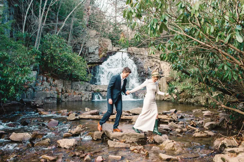noivos de m&atilde;os dadas na cachoeira