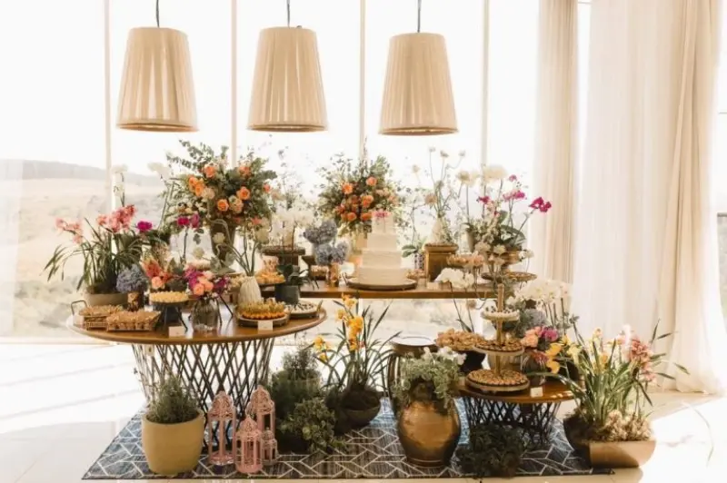 decora&ccedil;&atilde;o de mesa de doces desconstru&iacute;da para casamento em ambiente de campo, apresentando arranjos florais org&acirc;nicos e mobili&aacute;rio variado