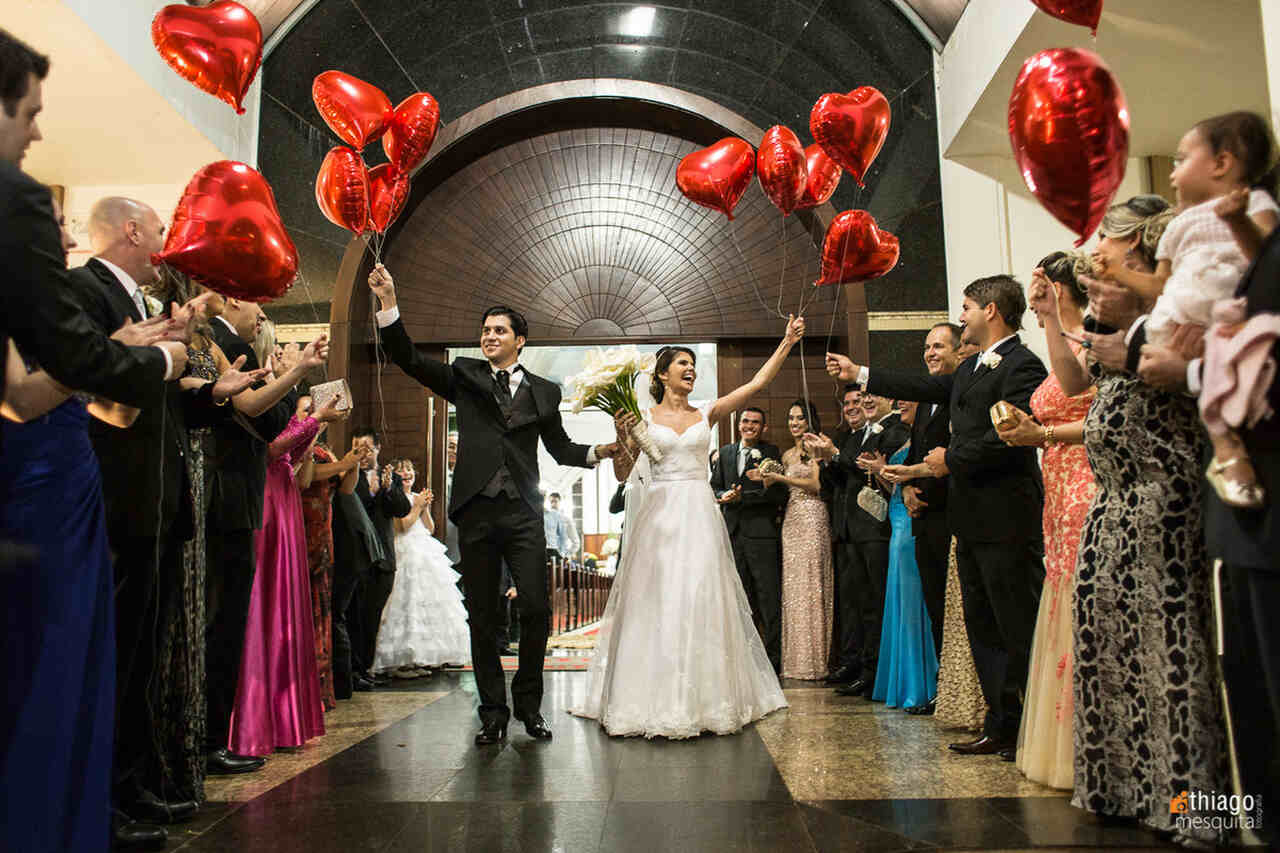 saída dos noivos da igreja católica com balões e corações