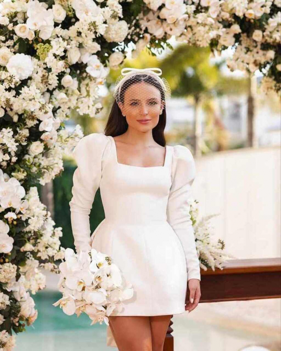 Noiva com vestido curto e buquê de flores brancas