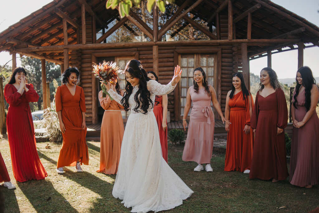 first look da noiva e madrinhas com vestidos terracota e vermelho em volta