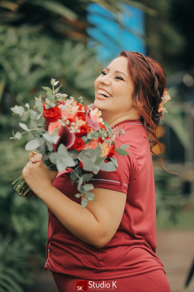 noiva com robe vermelho carregando buquê com flores rosas e vermelhas