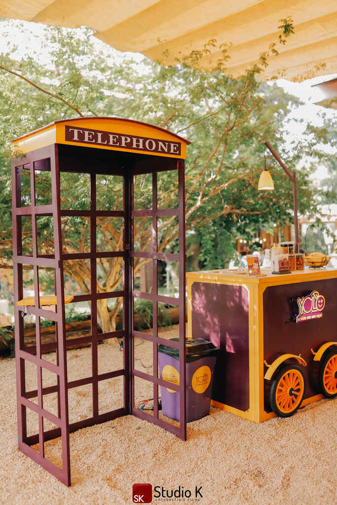 carrinho de açaí ao lado de cabine telefonica roxa para telefone de recados