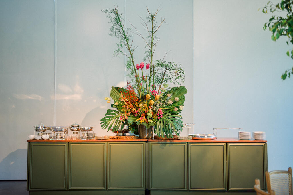 mesa de café decorada com arranjo de flores e plantas tropicais