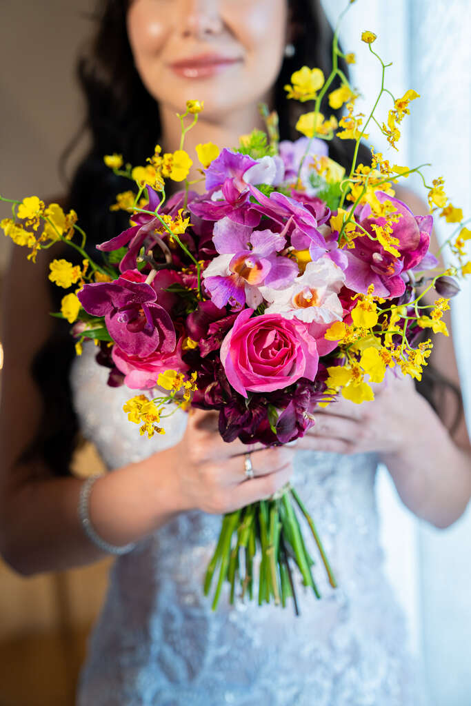 noiva com buquê com flores rosas na cor rosa flores amarelas e orquideas rosas