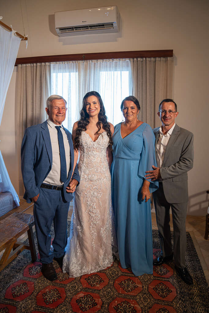 noiva ao lado do pai com tenro azul mãe com vestido azul serenity e homem com terno cinza