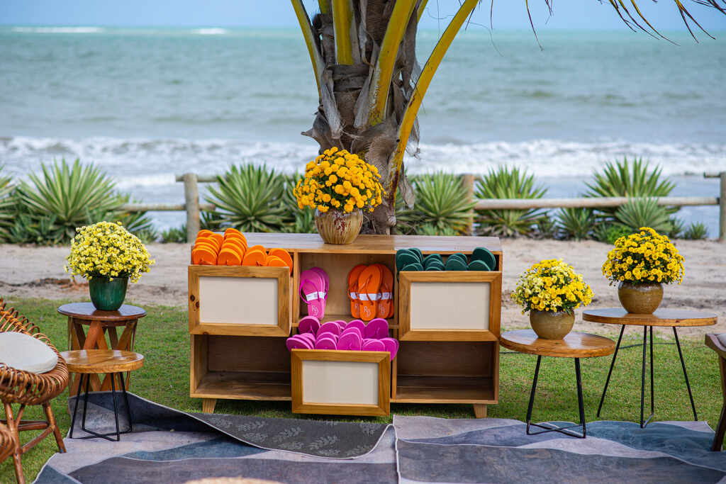 mesa de buffet com flores amarelas e chinelos coloridos para as lembrancinhas