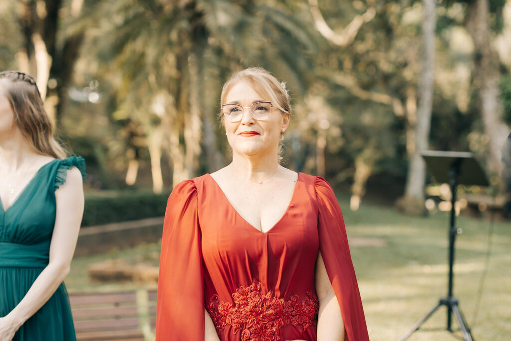 mãe da noiva com vestido vermelho com capa e detalhe floral na cintura