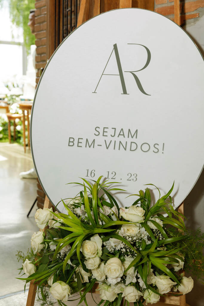 placa oval branca minimalista de bem-vindos com inciais do casal decorada com rosas brancas