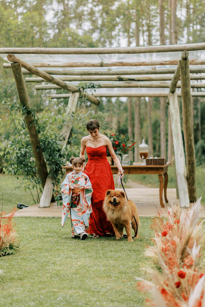 entrada da madrinha com vestido vermelho com cachorro e daminha com kimono colorido