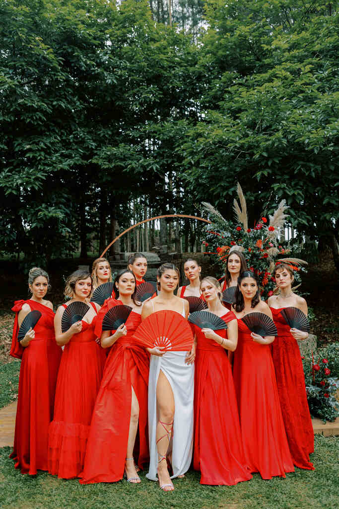 noiva ao lado das madrinhas com vestdios vermelhos com leques