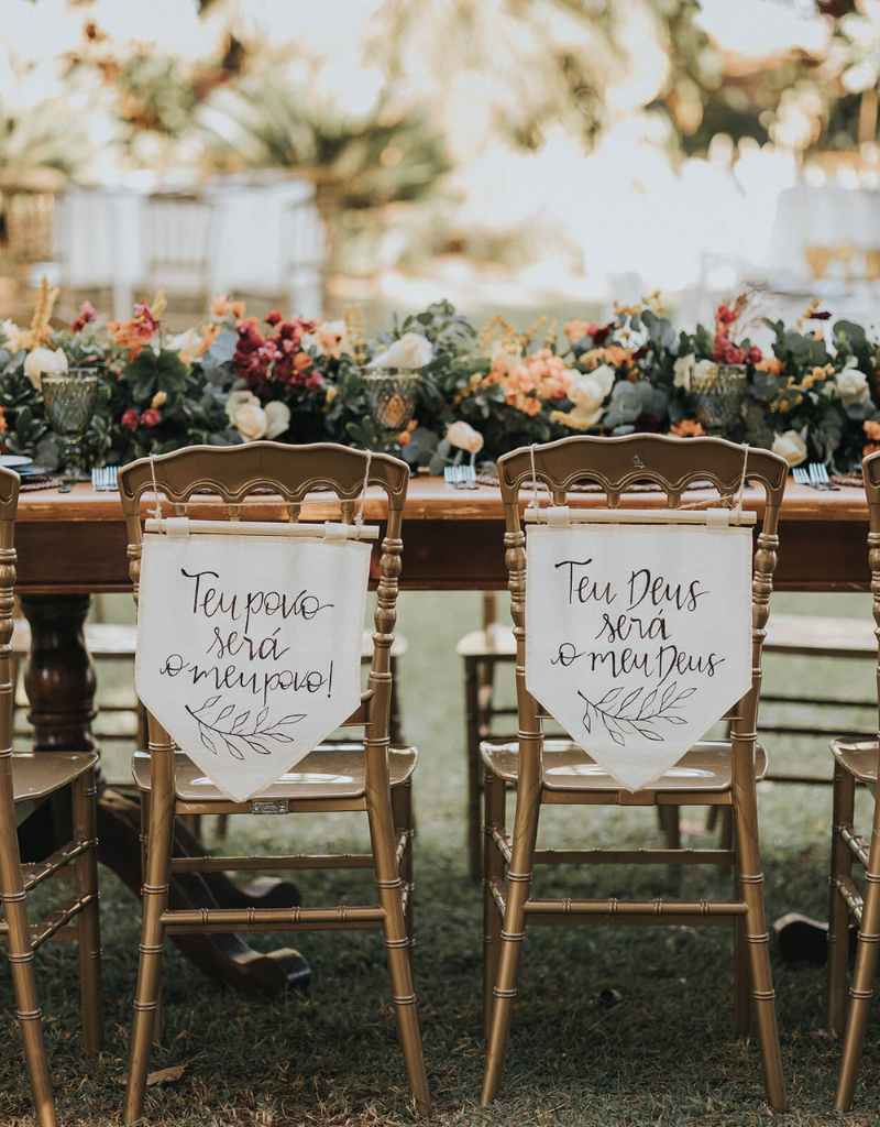 cadeira dos noivos decorada com flâmula de tecido cru com frase bíblica