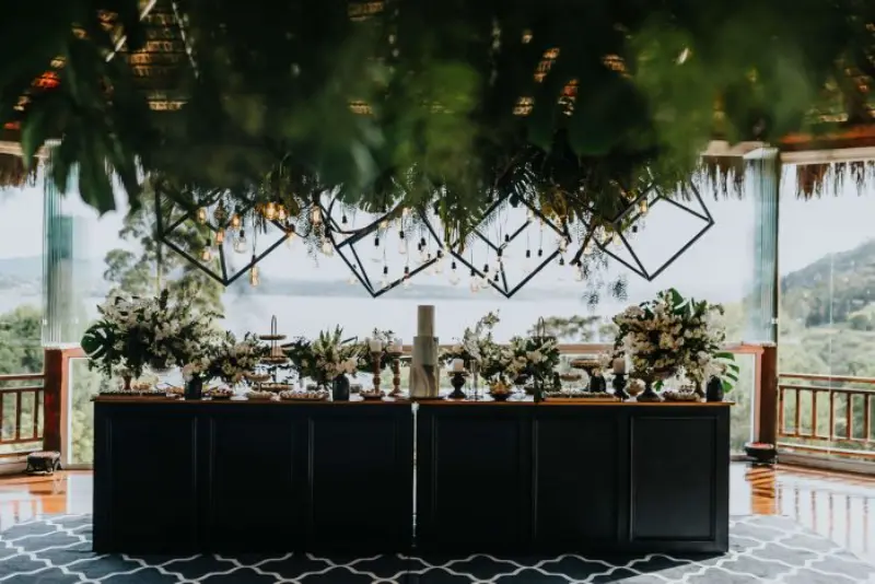 mesa do bolo de casamento moderno elegante com lustres geométricos