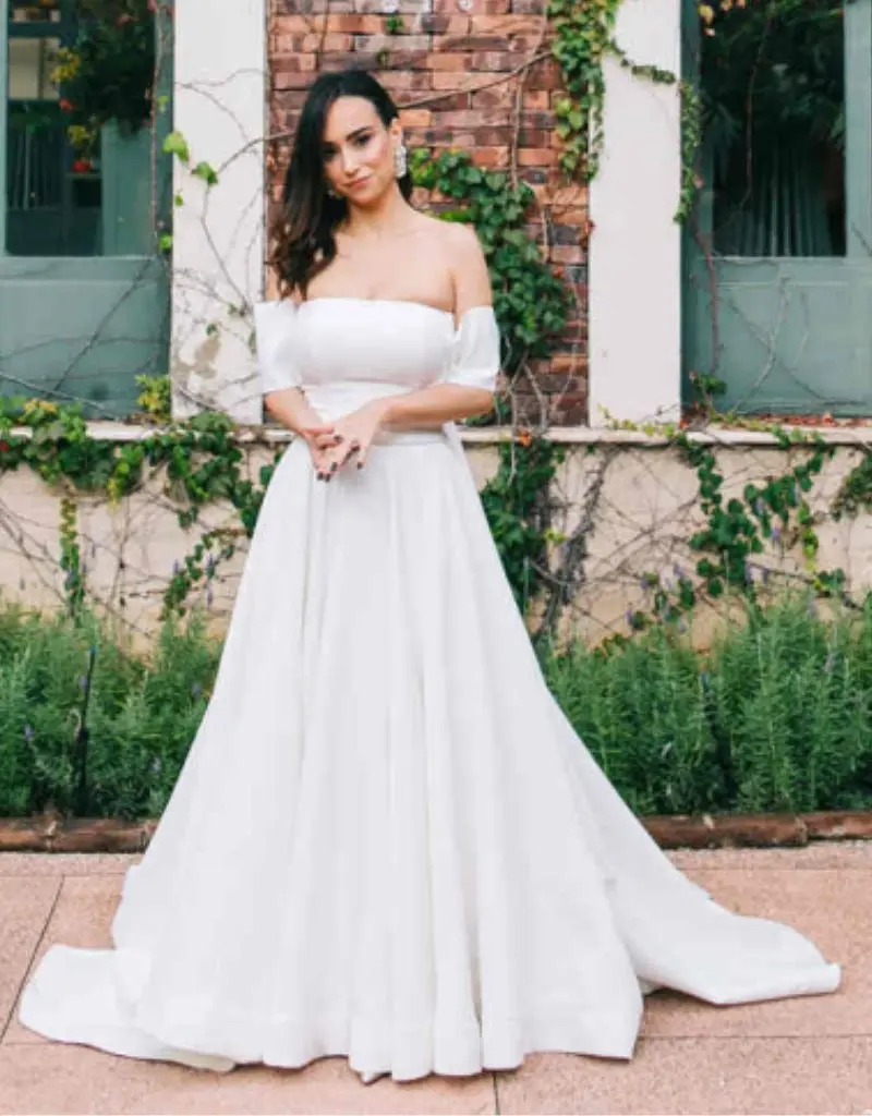 vestido de noiva simples longo com mangas curtas caindo abaixo do ombro