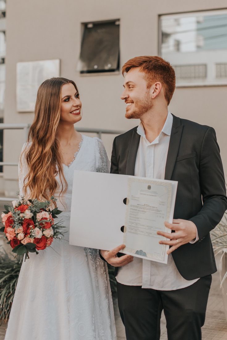 foto de casamento civil com noivos mostrando certidão de casamento