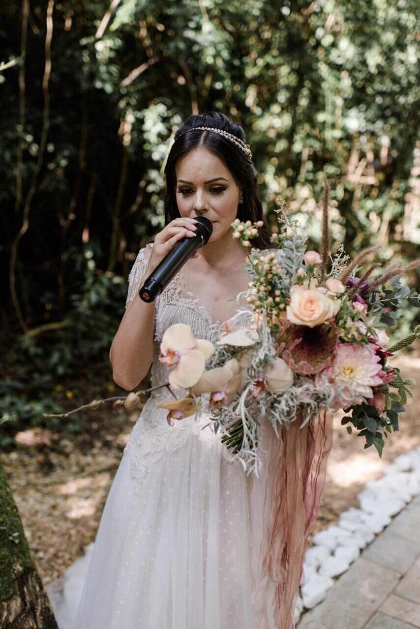 Noiva com o microfone cantando ao entrar no casamento