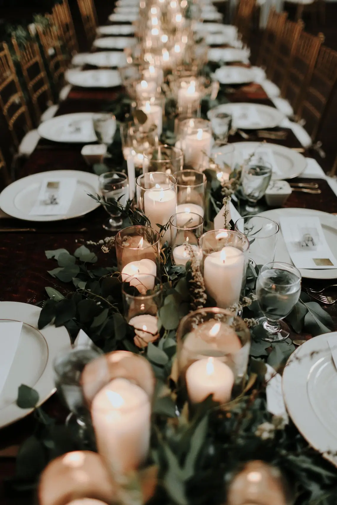 Velas sob a mesa dos convidados com flores e a louça